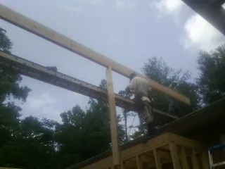 Carpenter setting a ridge beam over a new addition frame — Ice Dam Removal by Roofing Brothers in Kirkville