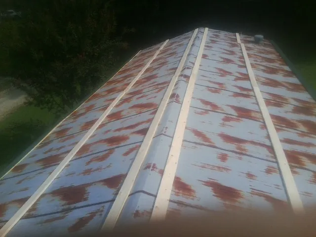 Rusted metal roof panels with new wood purlins before replacement — Storm Damage Roof Repair in Kirkville by Roofing Brothers