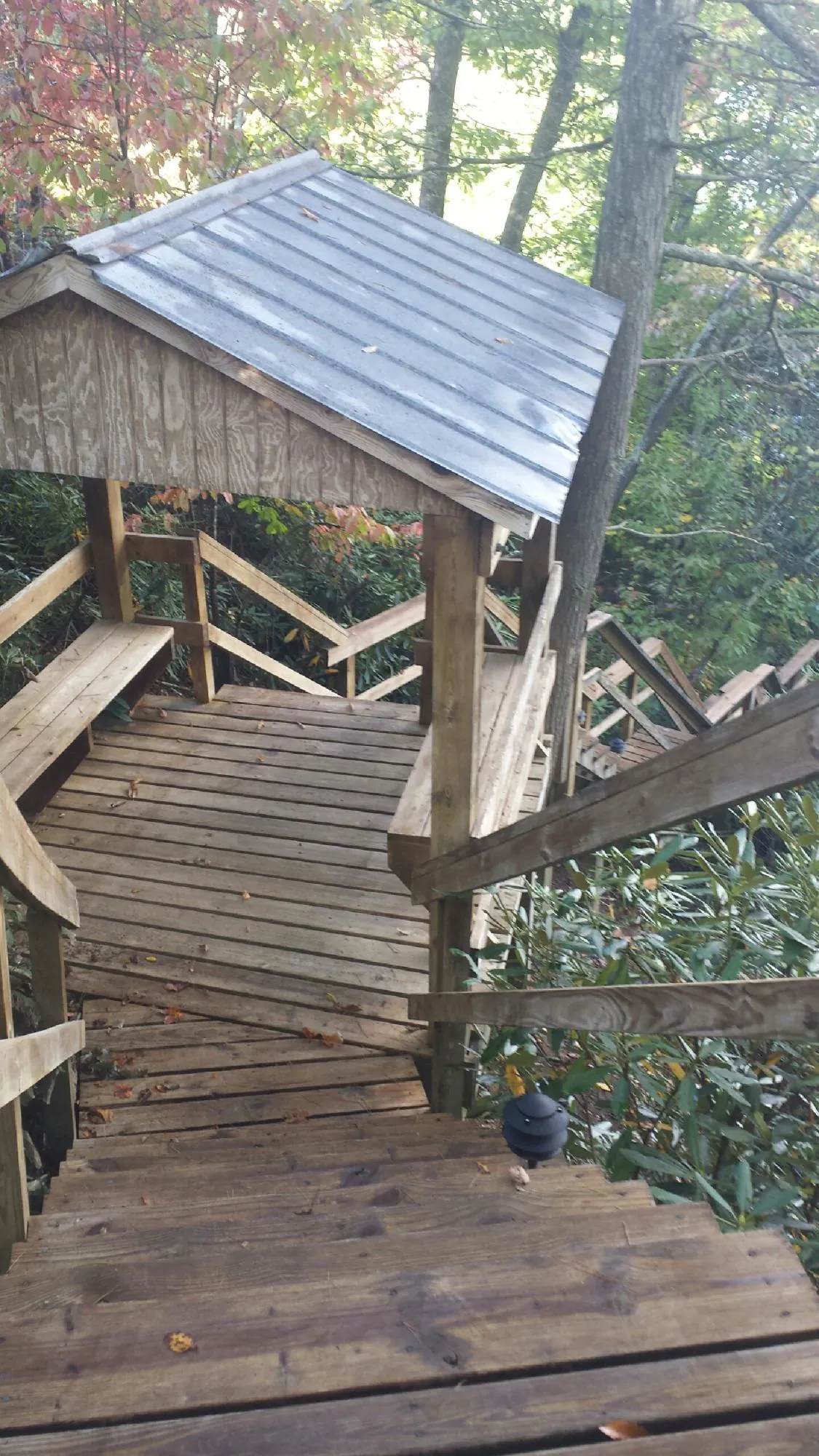 Metal roofed shelter over wooden steps on a wooded walkway — Skylight Repair & Installation work by our crew in Kirkville