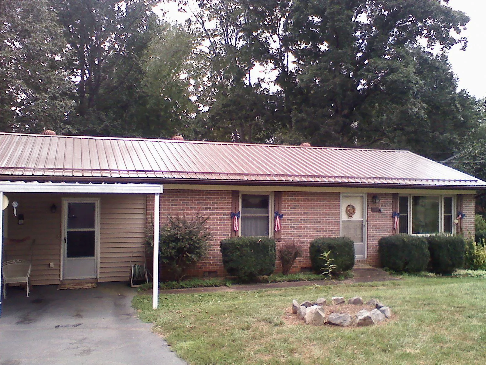 Bronze metal roof and carport on a brick ranch home — Roof Repair work by our crew in Kirkville